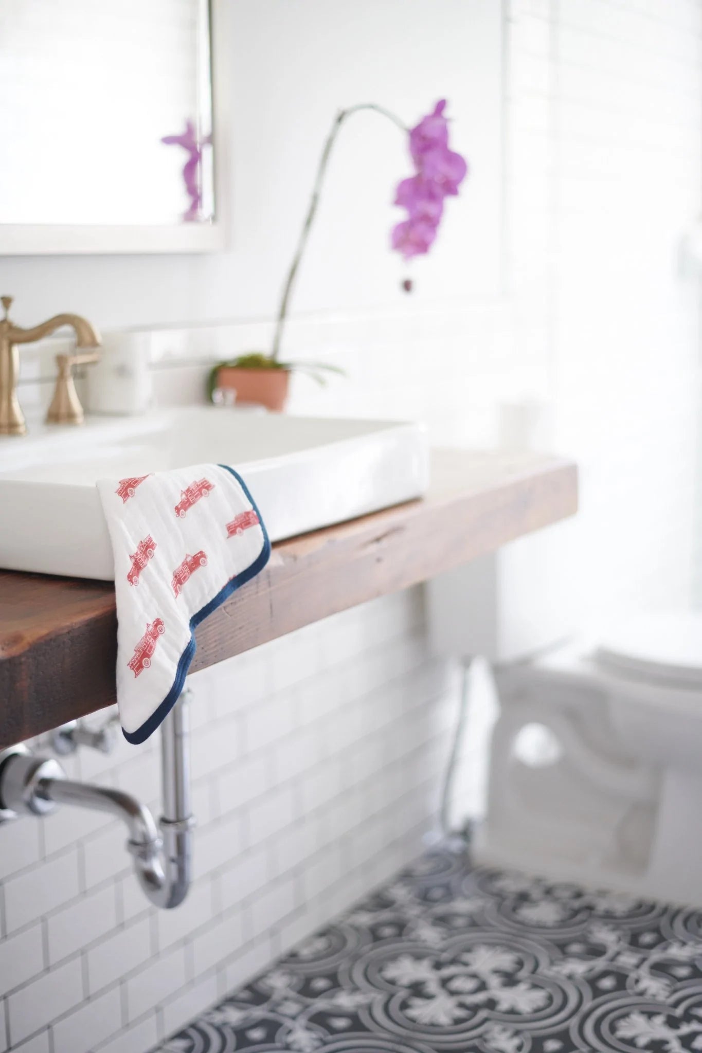 A colorful set of three plush cotton washcloths featuring vibrant fire truck designs, perfect for children's bath time.