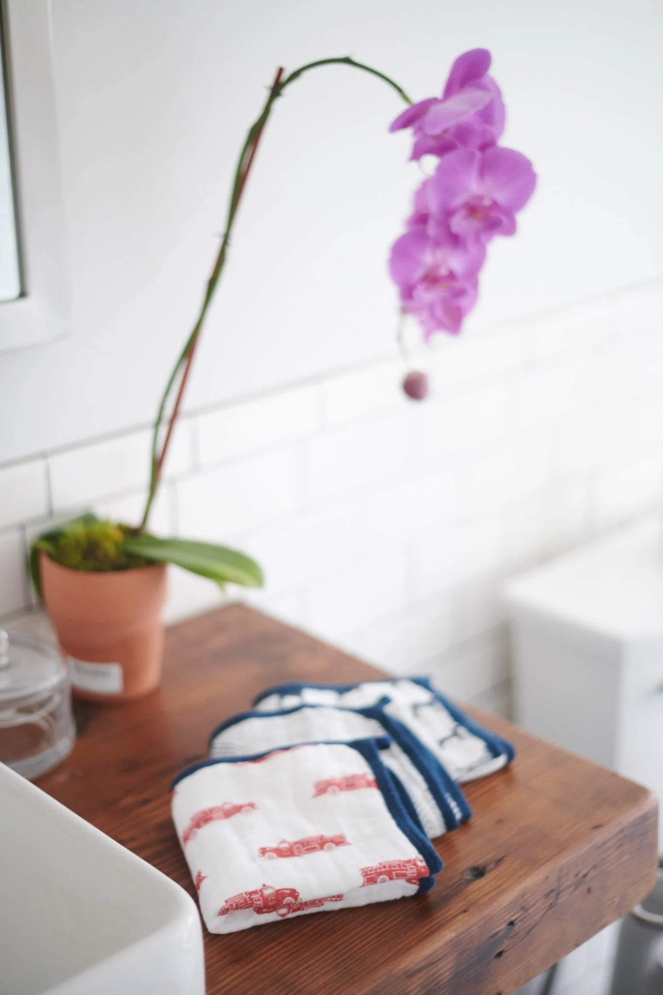 A colorful set of three plush cotton washcloths featuring vibrant fire truck designs, perfect for children's bath time.