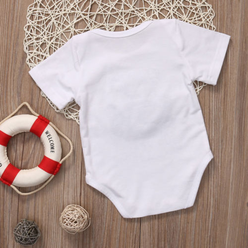 White baby onesie on floor.