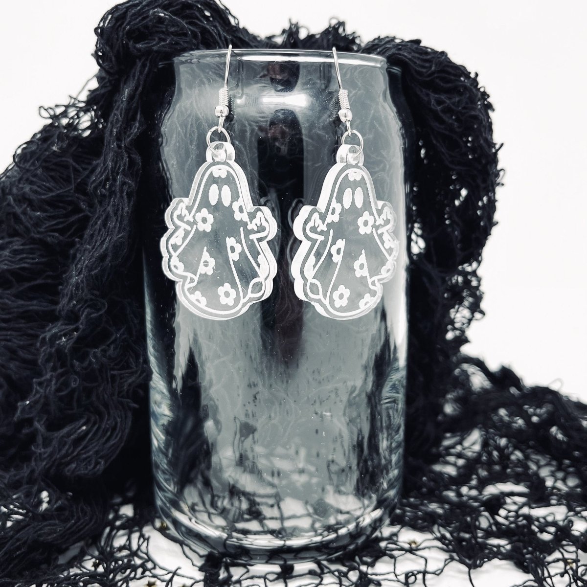 A pair of acrylic ghost dangle earrings featuring a laser-engraved daisy ghost design, perfect for adding a spooky touch to any outfit.