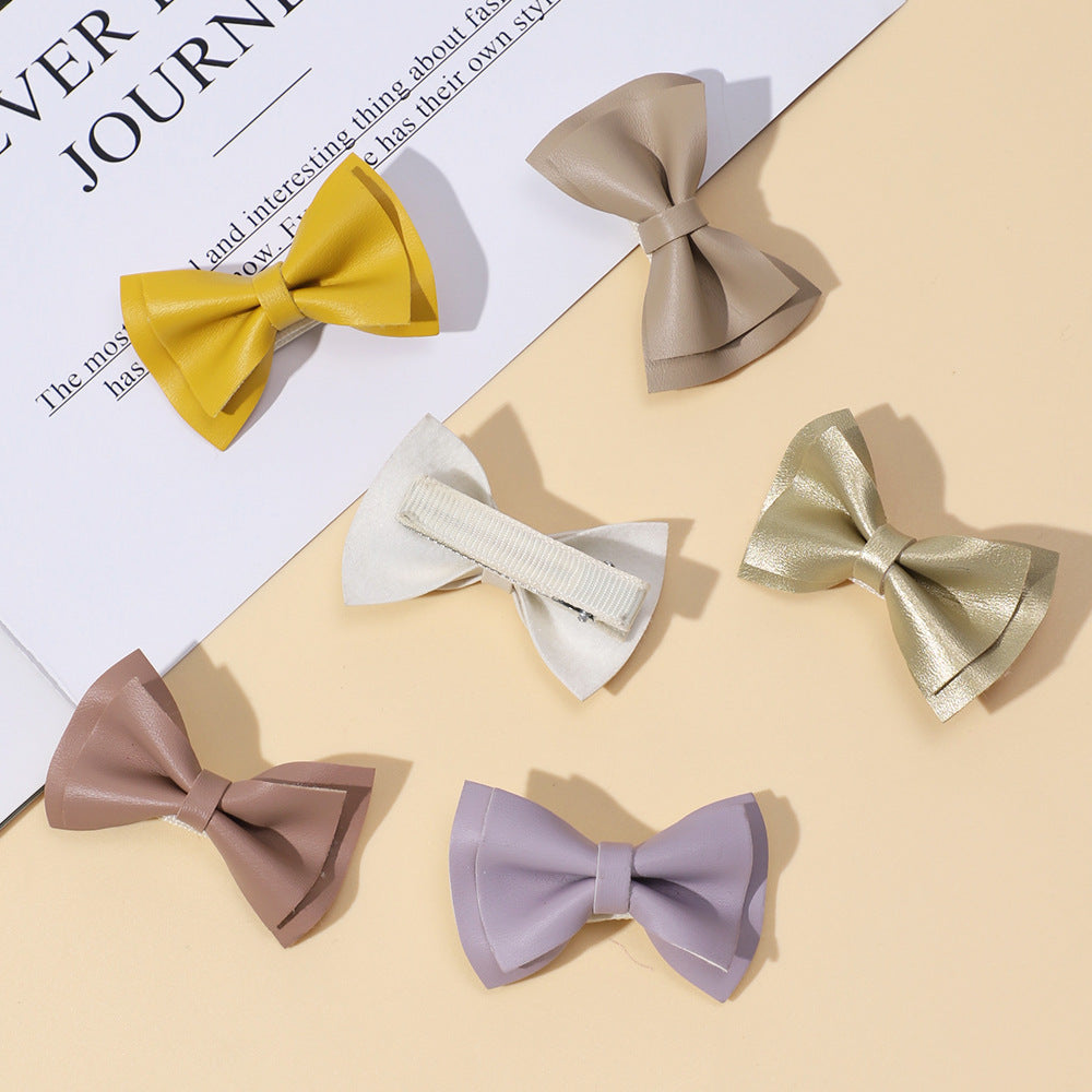 Handmade cloth bow tie hair clips for girls in various colors including white, purple, yellow, khaki, gold, and brown.