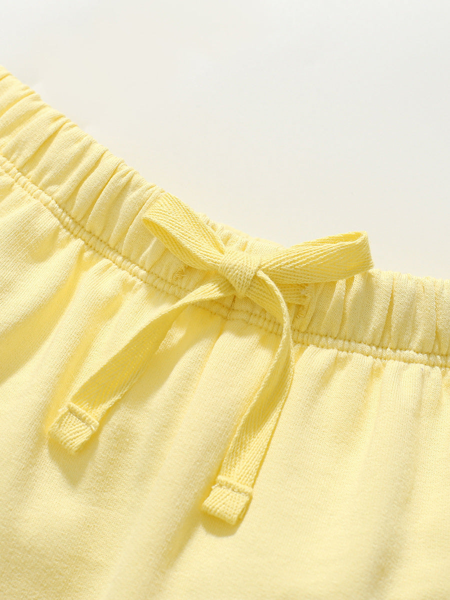 Girls solid color yellow capri pants with rainbow logo, made from soft cotton, perfect for summer wear.