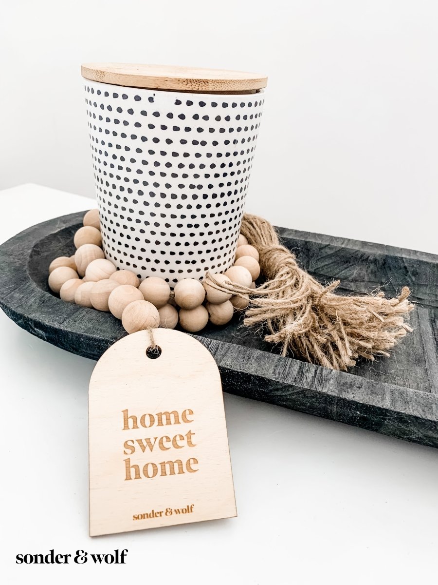 Home Sweet Home Garland featuring natural wood beads and a jute tassel, perfect for home decor.