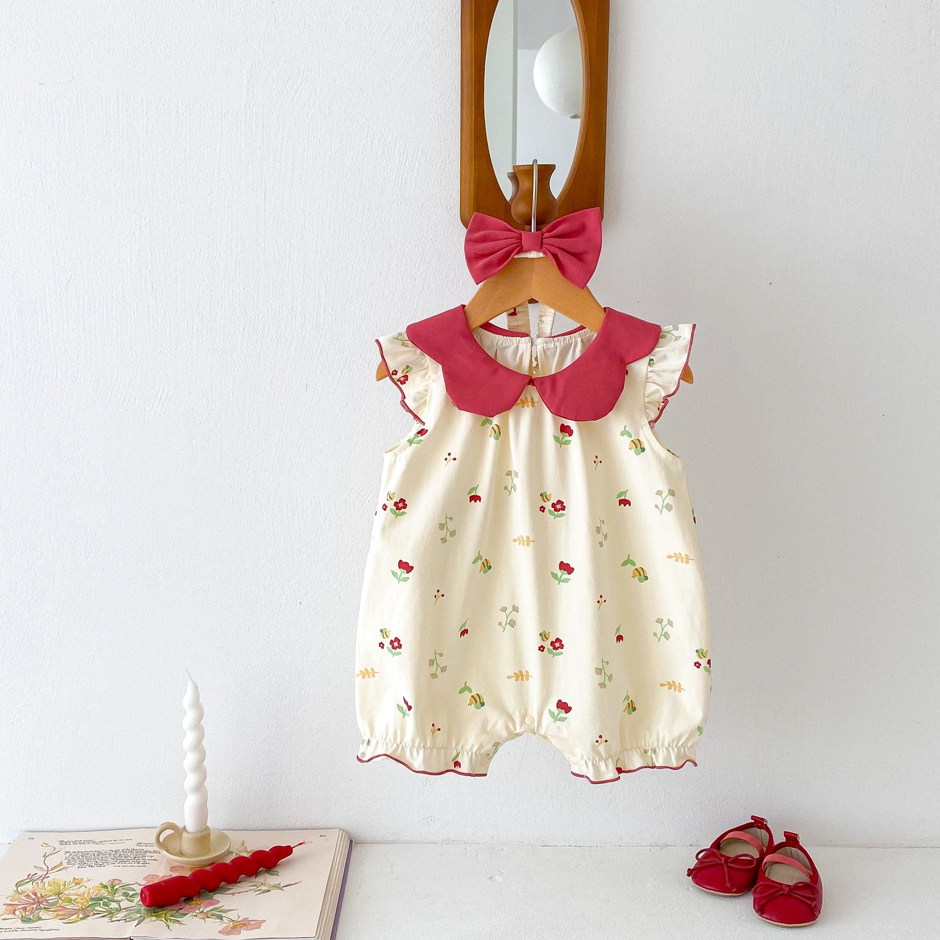 A vibrant red sleeveless dress for baby girls featuring a floral pattern, perfect for summer wear.