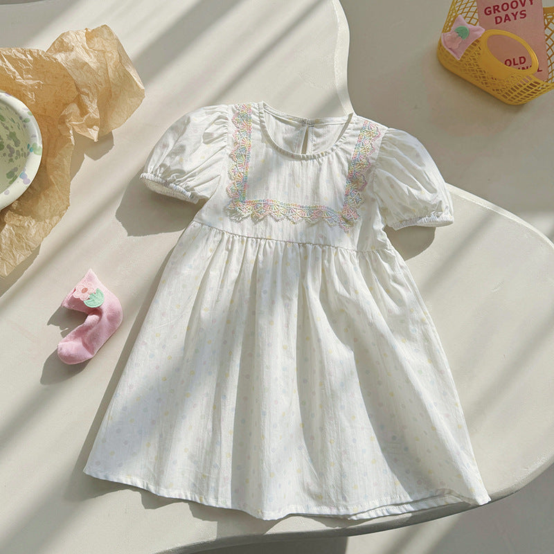 A beige summer dress for girls featuring short sleeves and a playful polka dot pattern, perfect for warm weather outings.