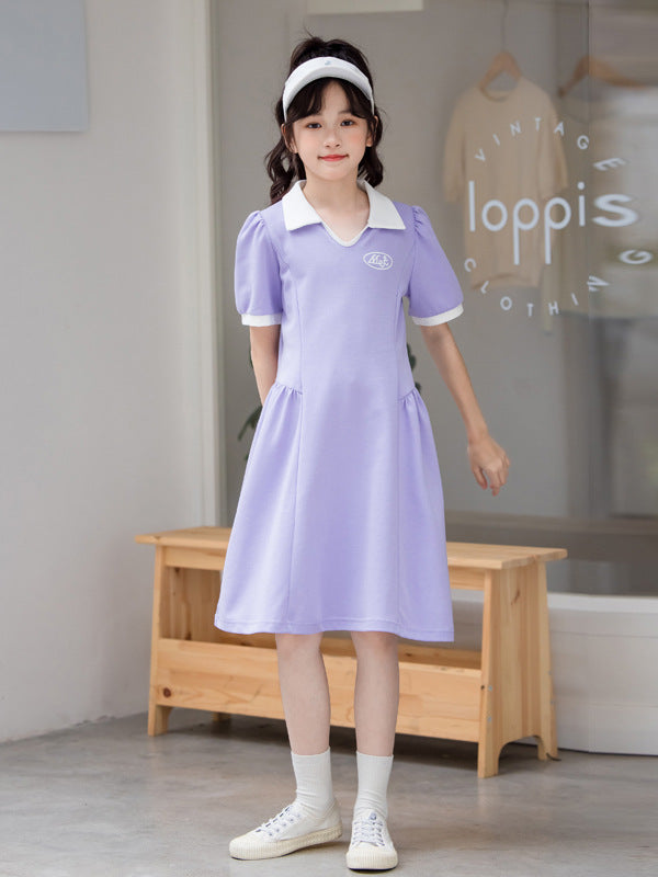 A vibrant purple short-sleeve shirt for girls, made from soft cotton, featuring a trendy letter pattern, perfect for summer activities.