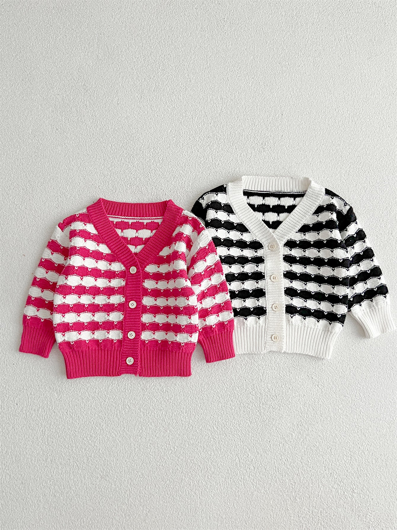 Infant baby boys and girls striped long-sleeved cardigan in black and pink colors, made of soft cotton material.