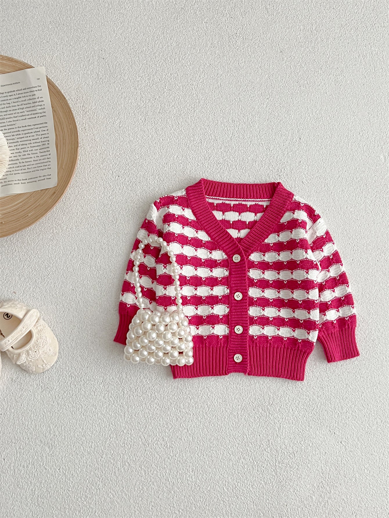 Infant baby boys and girls striped long-sleeved cardigan in black and pink colors, made of soft cotton material.