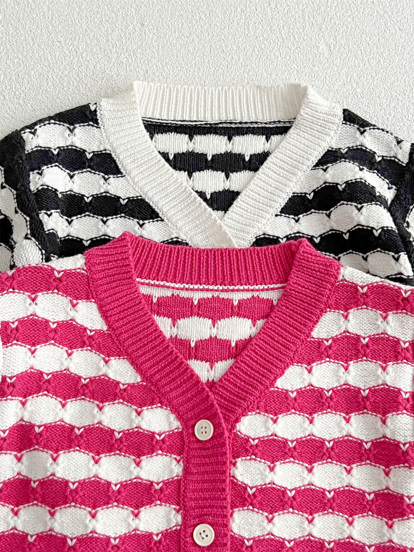 Infant baby boys and girls striped long-sleeved cardigan in black and pink colors, made of soft cotton material.