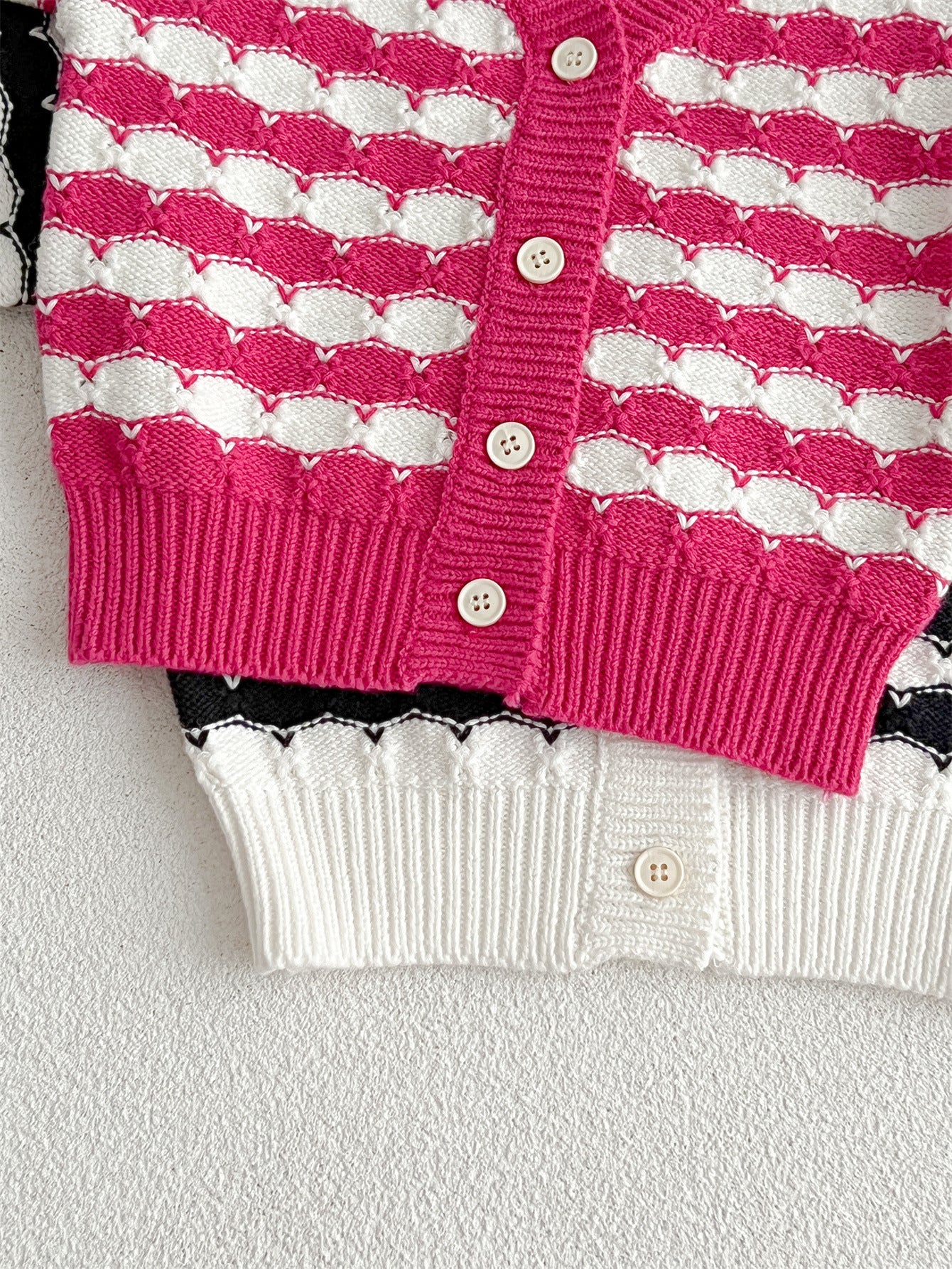 Infant baby boys and girls striped long-sleeved cardigan in black and pink colors, made of soft cotton material.