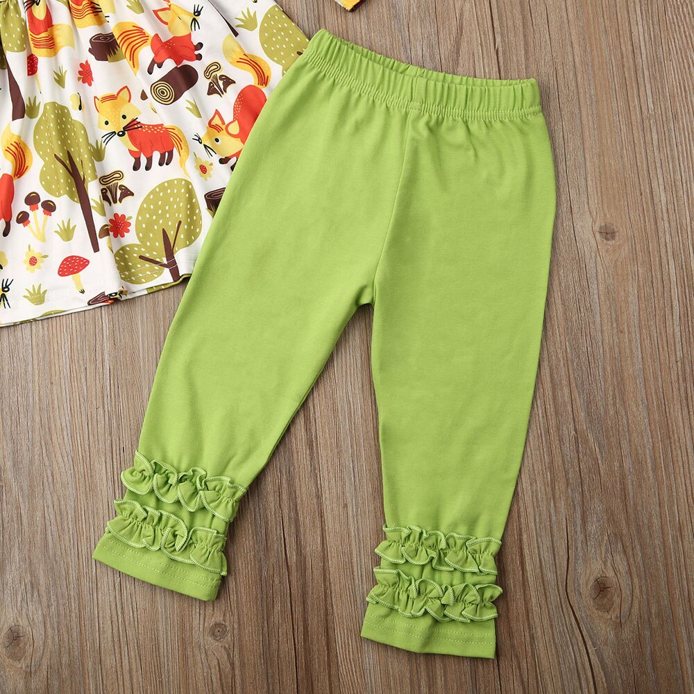 Green ruffled leggings on wood floor.