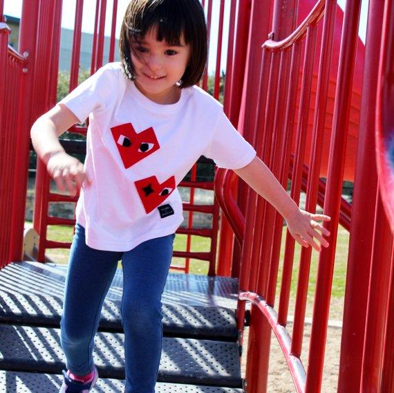 Kids T-shirt featuring I Heart design by Donald Robertson, handmade with felt appliqué on a white fabric.