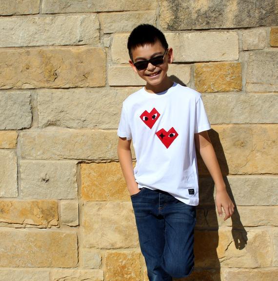 Kids T-shirt featuring I Heart design by Donald Robertson, handmade with felt appliqué on a white fabric.