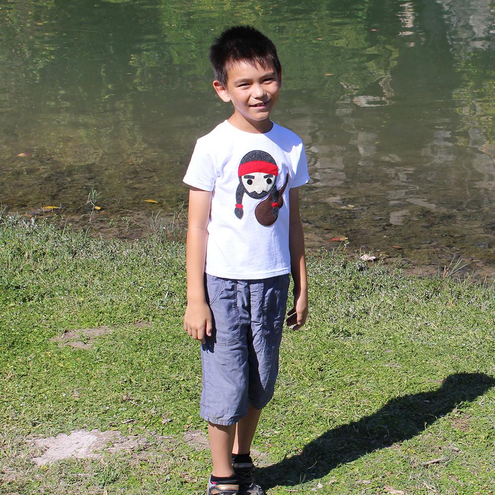 A colorful kids T-shirt featuring Willie the Music Man playing guitar, made with eco-friendly felt appliqué.