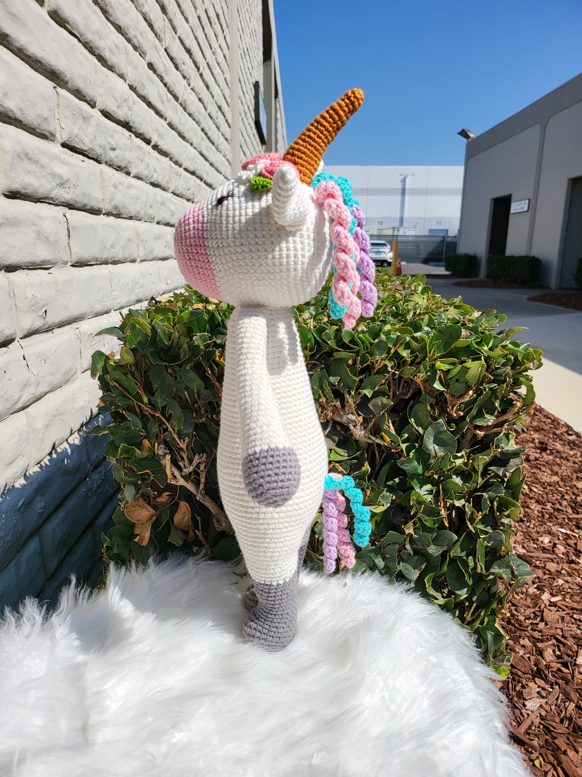 A large standing unicorn crochet toy made from 100% cotton yarn, featuring a colorful mane and tail, perfect for children and collectors.