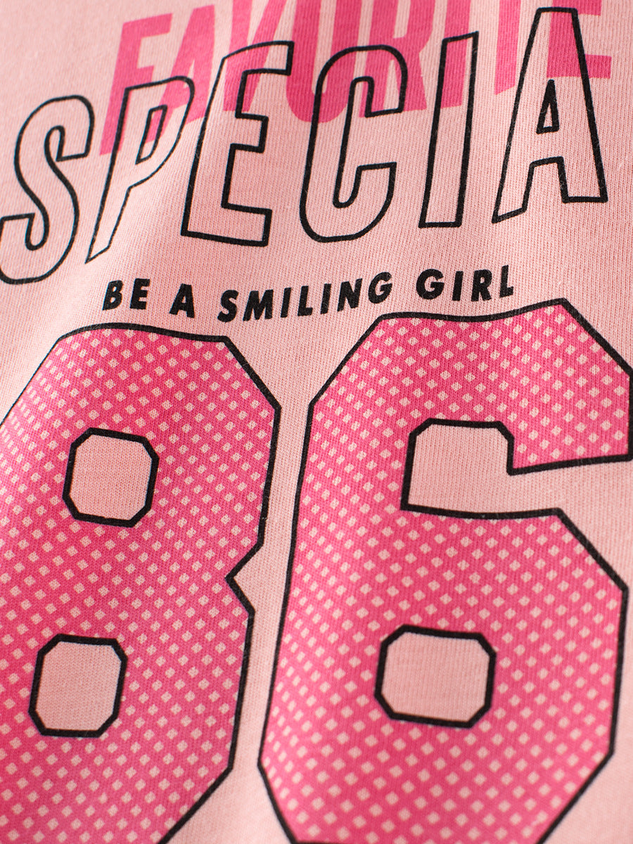 A vibrant pink and apricot girls' t-shirt featuring a playful letters print, perfect for summer wear.