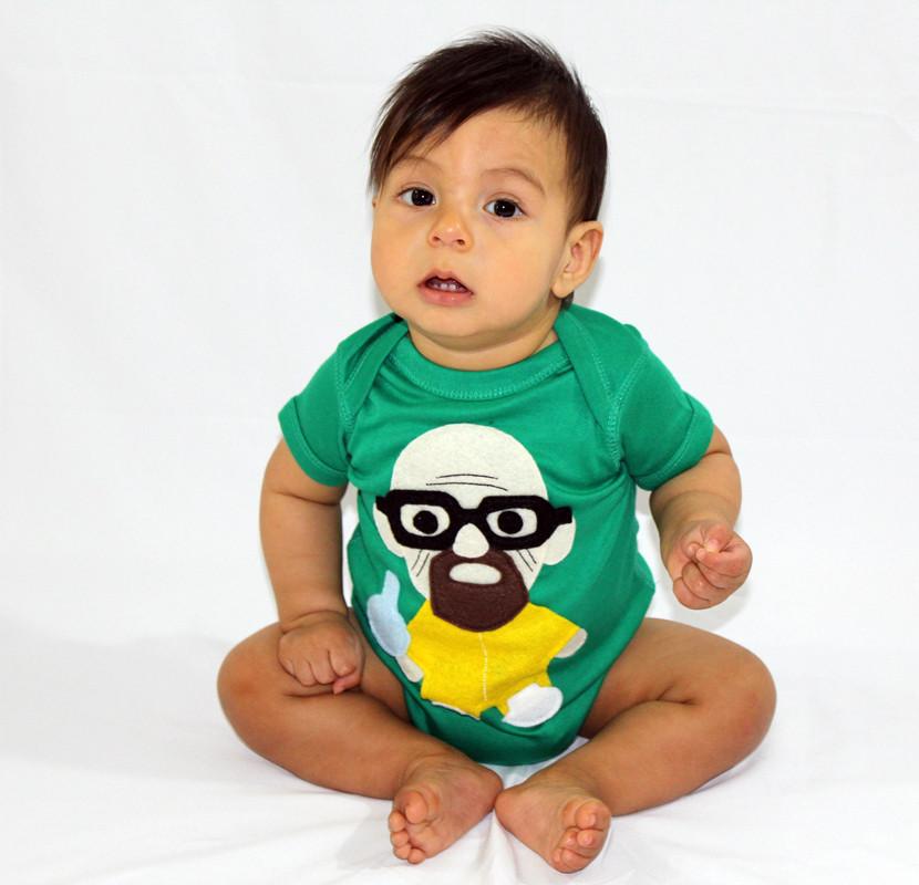 A playful green onesie featuring a character holding a flask, perfect for little chefs.