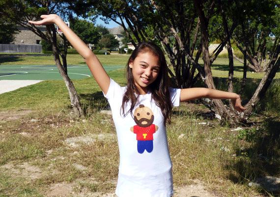 A stylish white women's t-shirt featuring unique red and blue appliqué designs and a golden necklace motif, handmade with love.