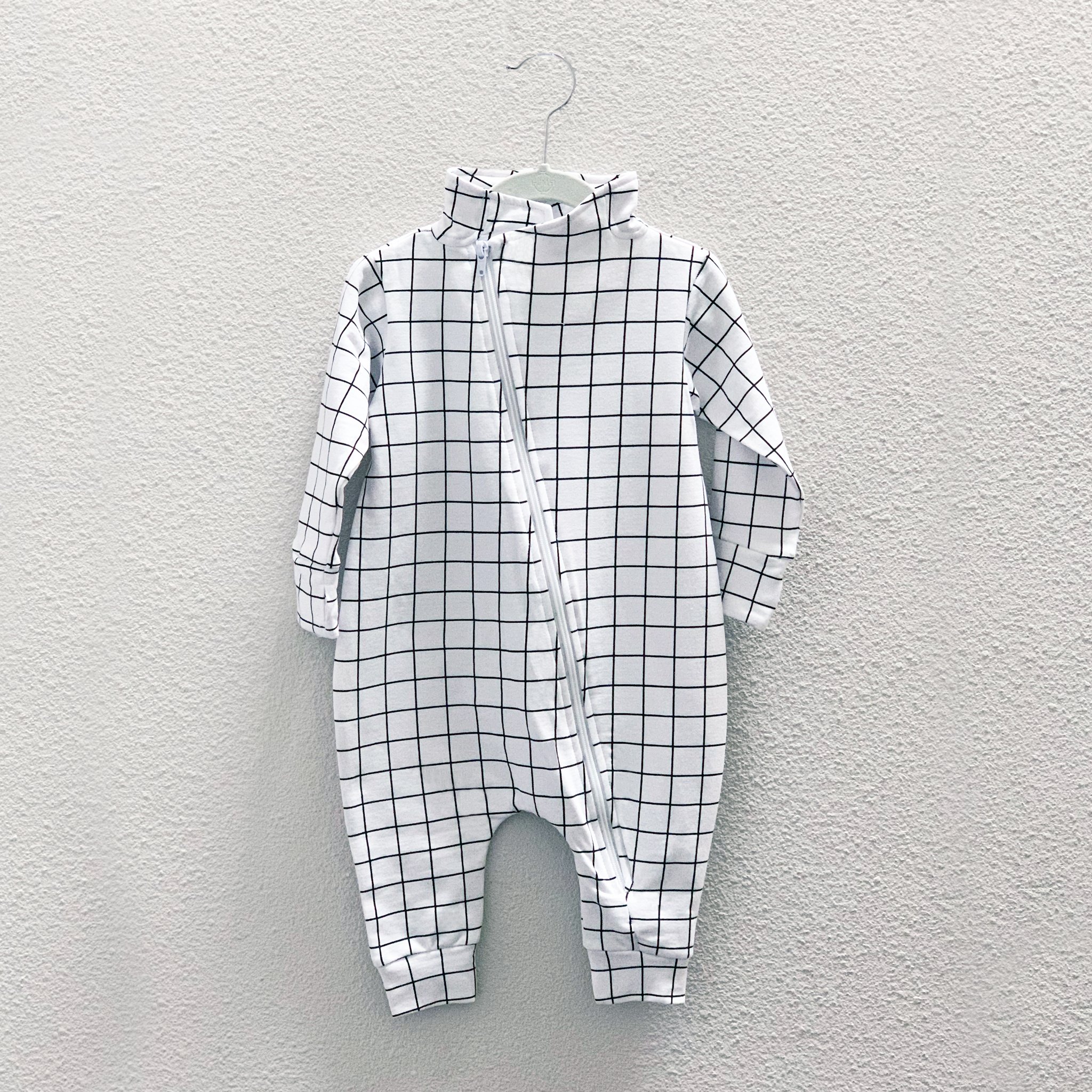 Maverick Romper in Black/White Grid featuring long sleeves, asymmetric zip, and structured collar.