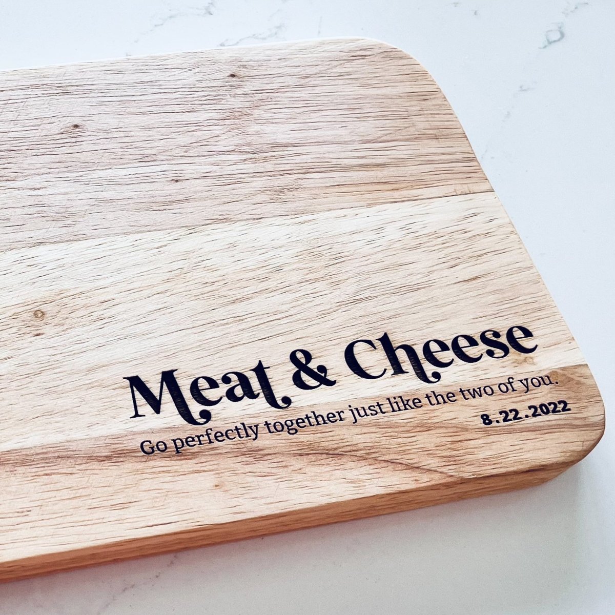 A beautifully crafted Meat & Cheese Charcuterie Board featuring a rustic wood grain finish, perfect for serving assorted meats and cheeses.