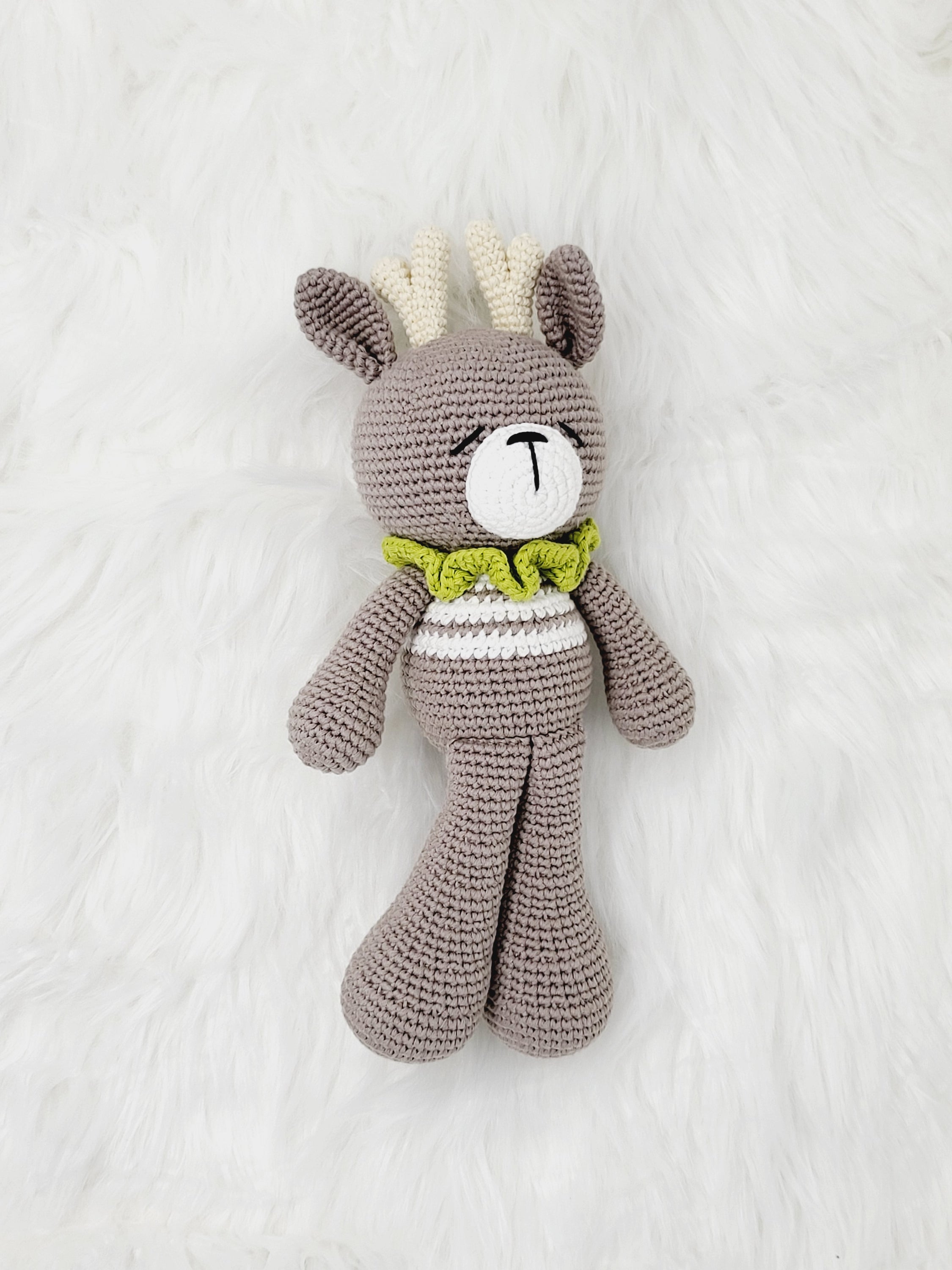 A charming Medium Sitting Reindeer crochet toy made from 100% cotton yarn, featuring a friendly face and cozy sitting posture.