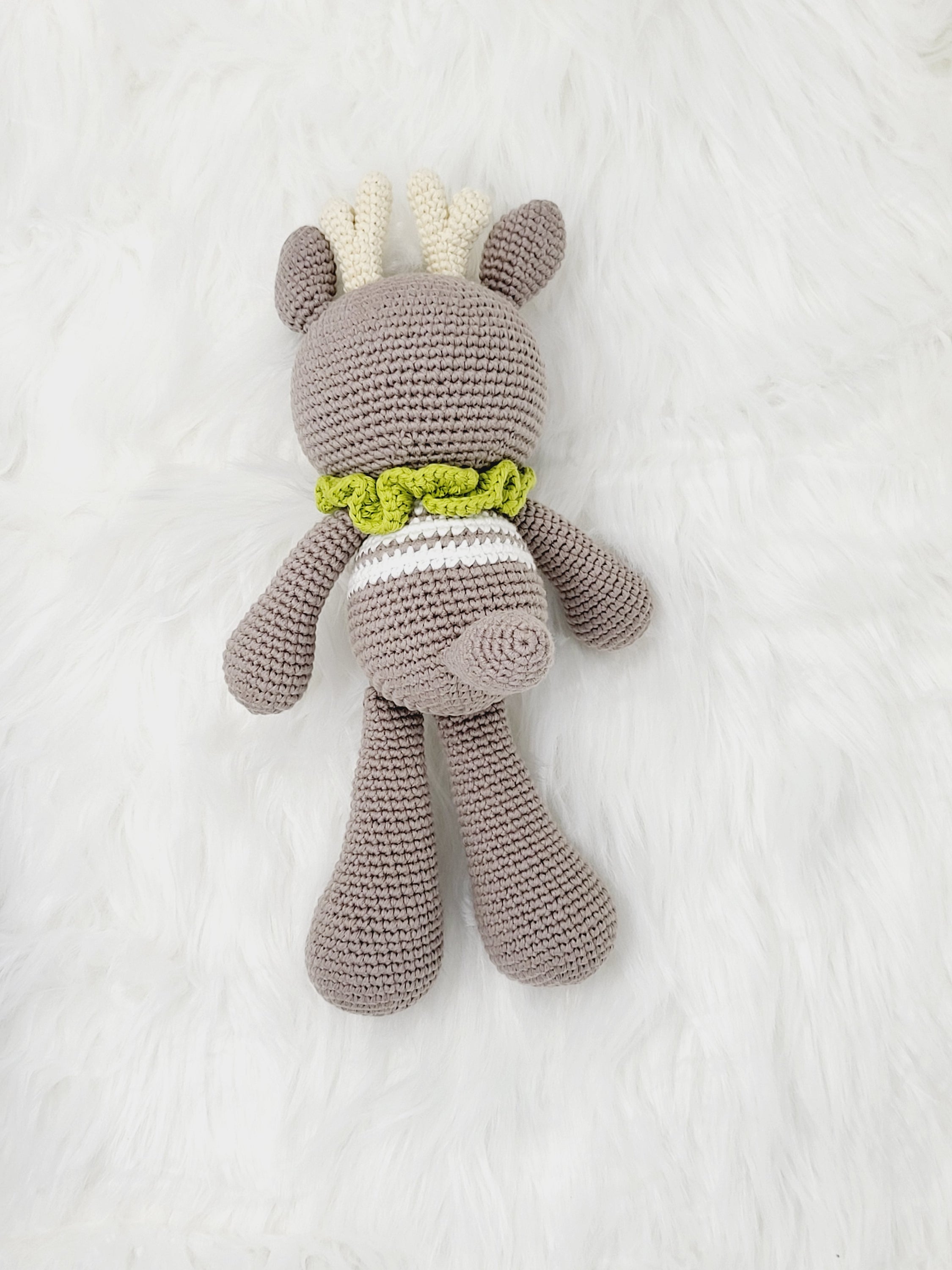 A charming Medium Sitting Reindeer crochet toy made from 100% cotton yarn, featuring a friendly face and cozy sitting posture.