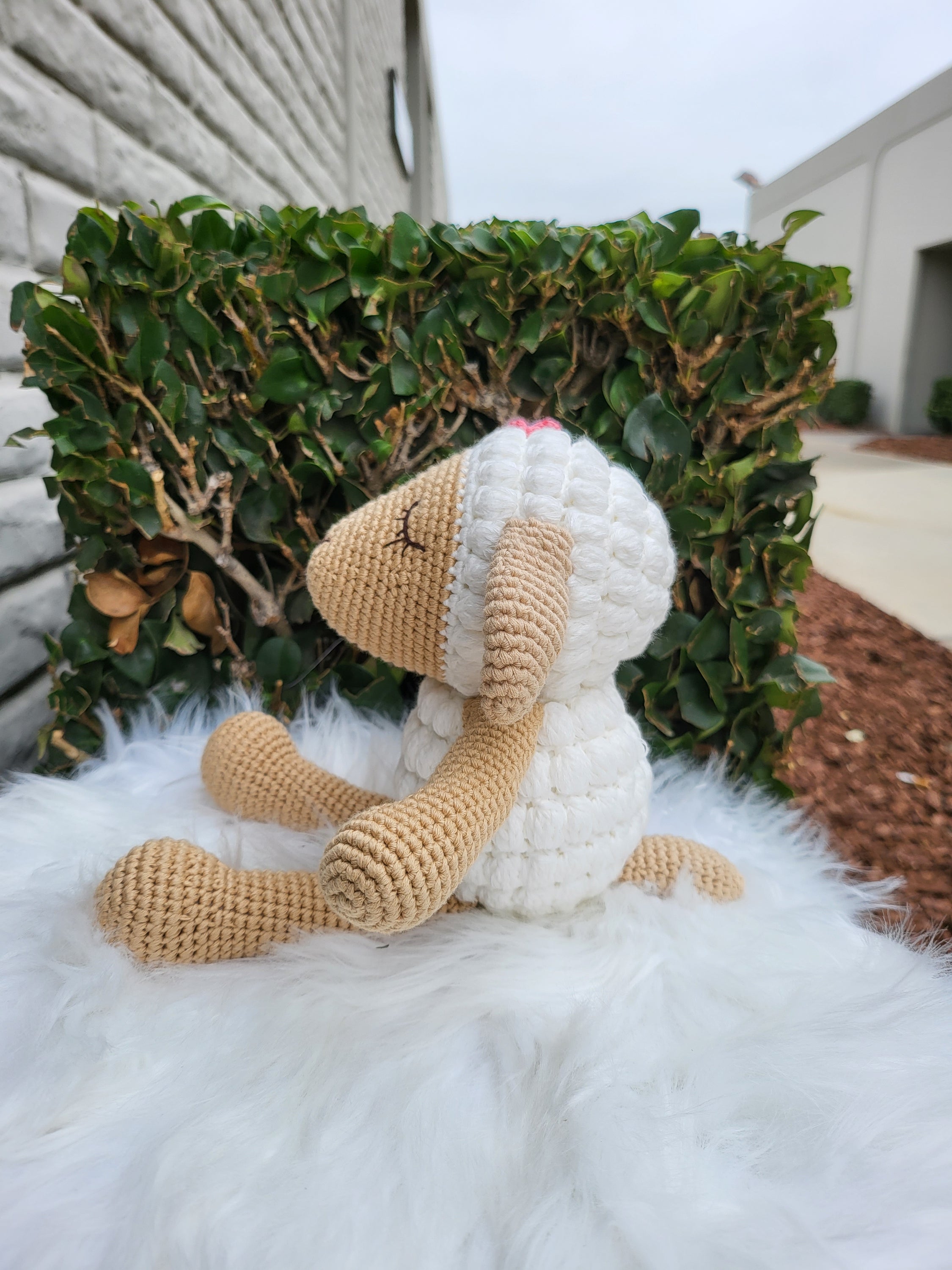 A charming medium-sized sitting sheep crochet toy made from 100% cotton yarn, featuring a soft texture and unique handmade design.