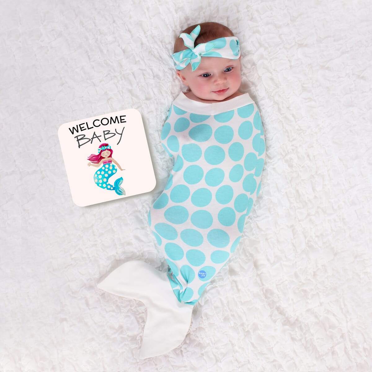 Mermaid Baby cocoon swaddle set featuring soft fabric, matching headpiece, and announcement card, designed for newborn comfort.