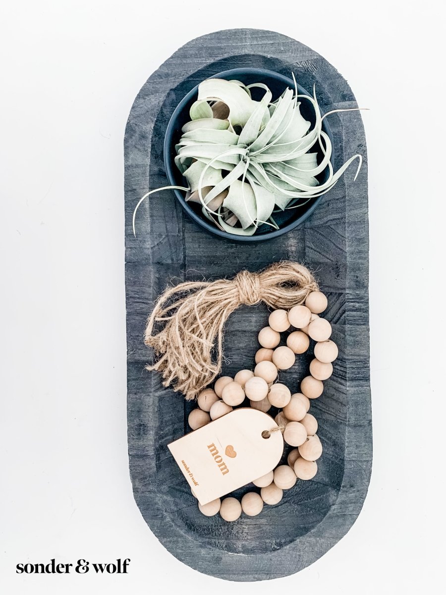 Mom Garland featuring light wood beads and a jute tassel, perfect for home decor.