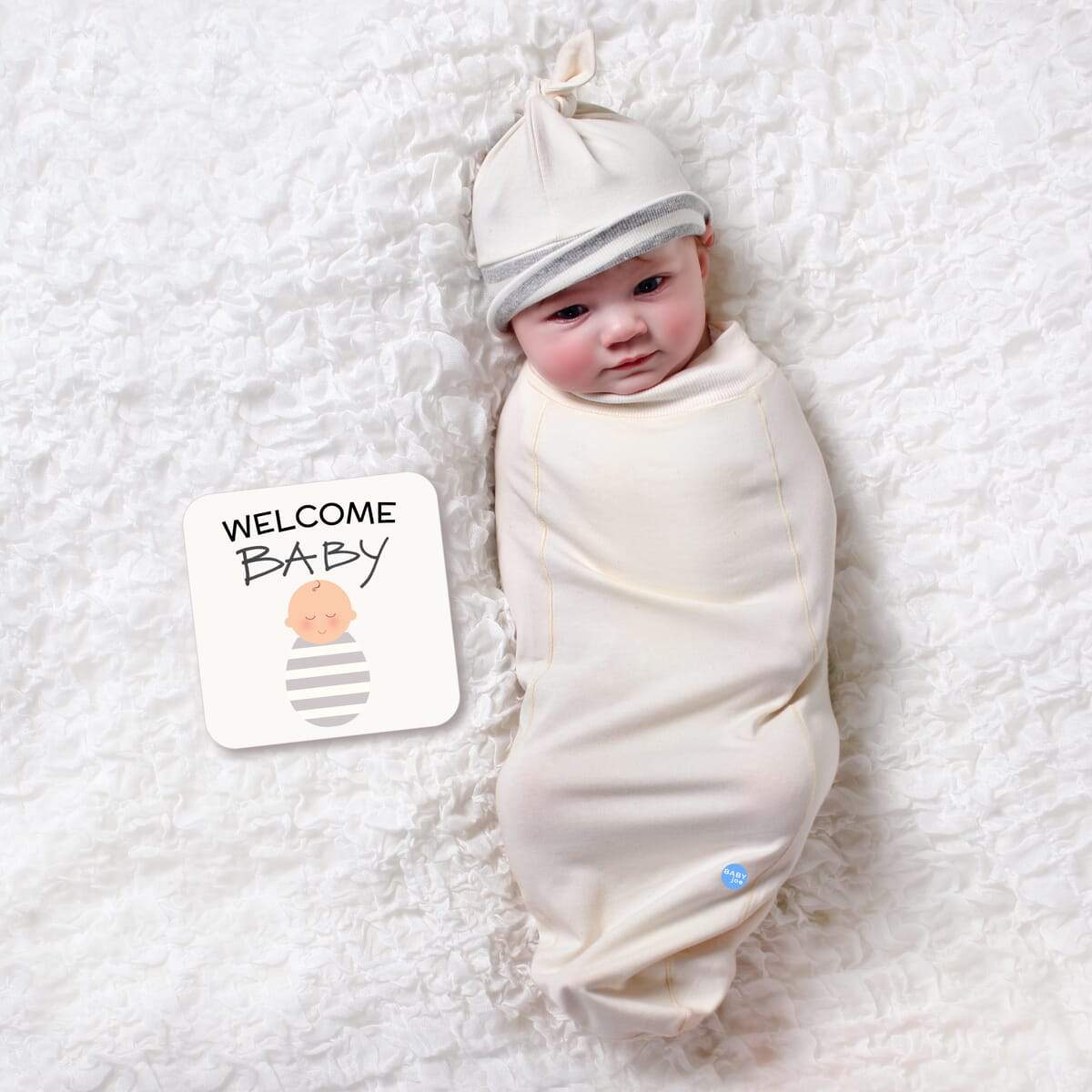 Natural Baby cocoon swaddle set including swaddle, headpiece, and announcement card, designed for newborn comfort.