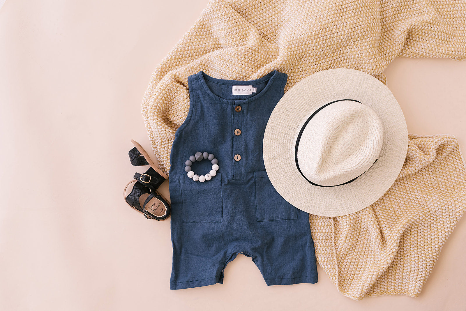 A stylish navy crop linen romper for babies, featuring diaper snaps and a comfortable fit, perfect for various occasions.