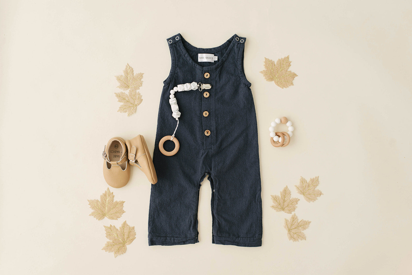 A stylish navy linen romper for babies, featuring diaper snaps and a comfortable fit, perfect for various occasions.