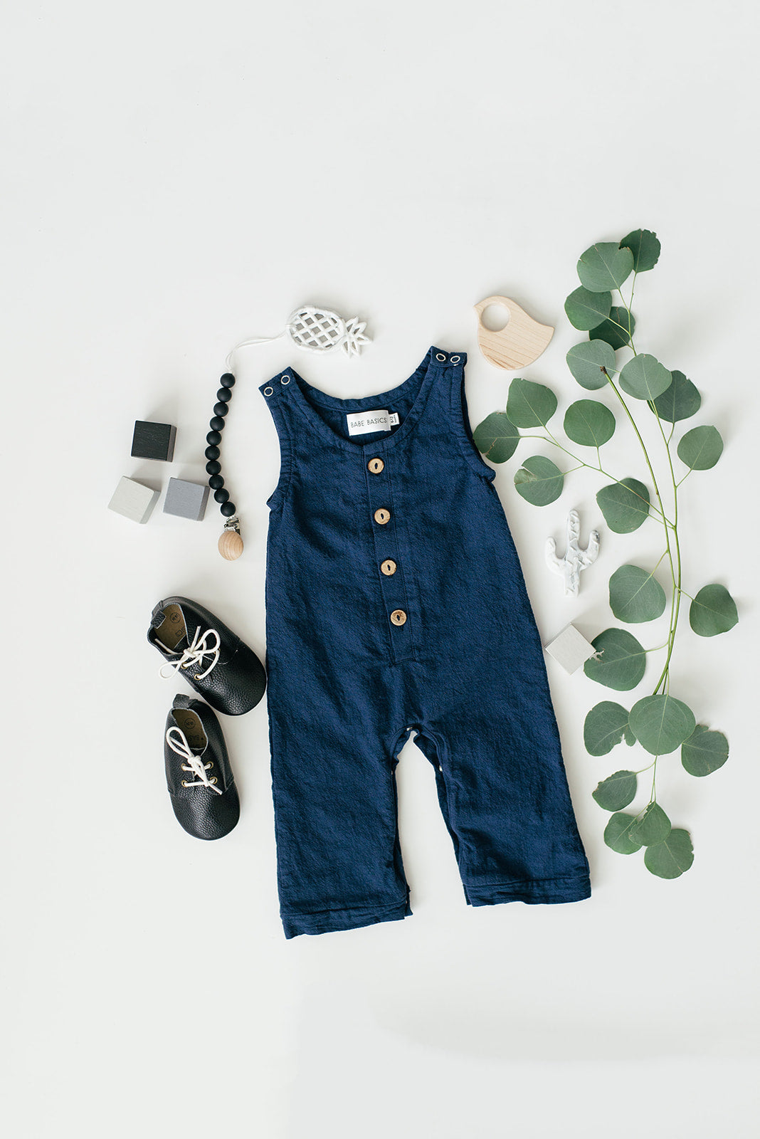 A stylish navy linen romper for babies, featuring diaper snaps and a comfortable fit, perfect for various occasions.