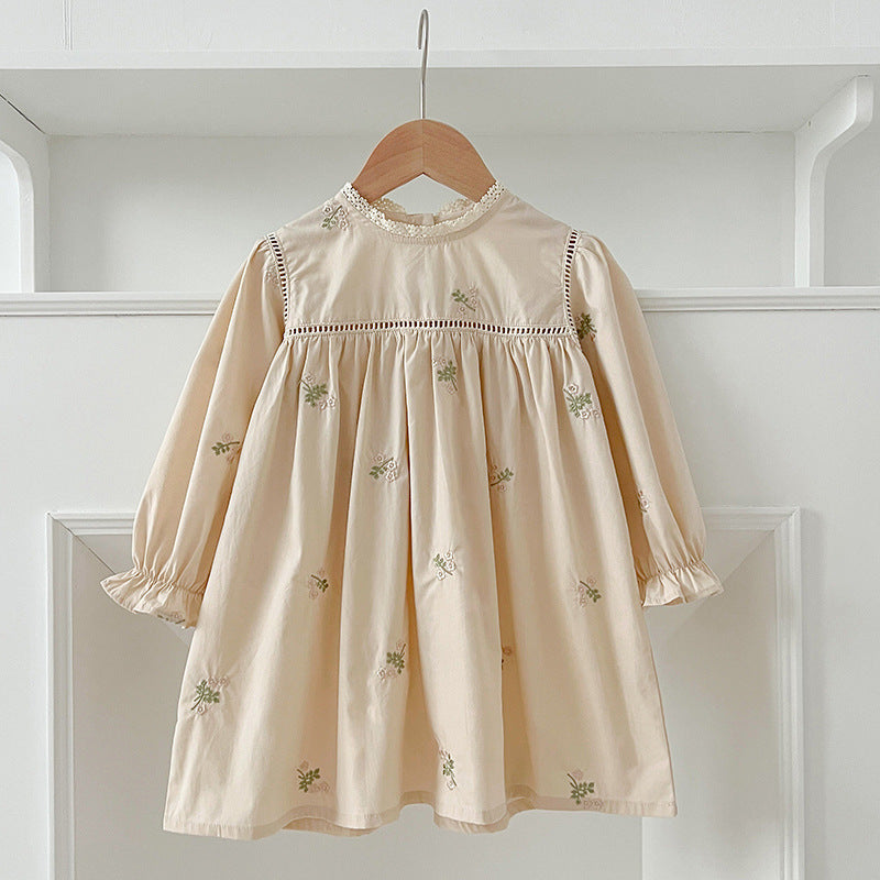 A beautiful baby girls dress featuring floral embroidery and lace trim, available in beige and apricot colors.