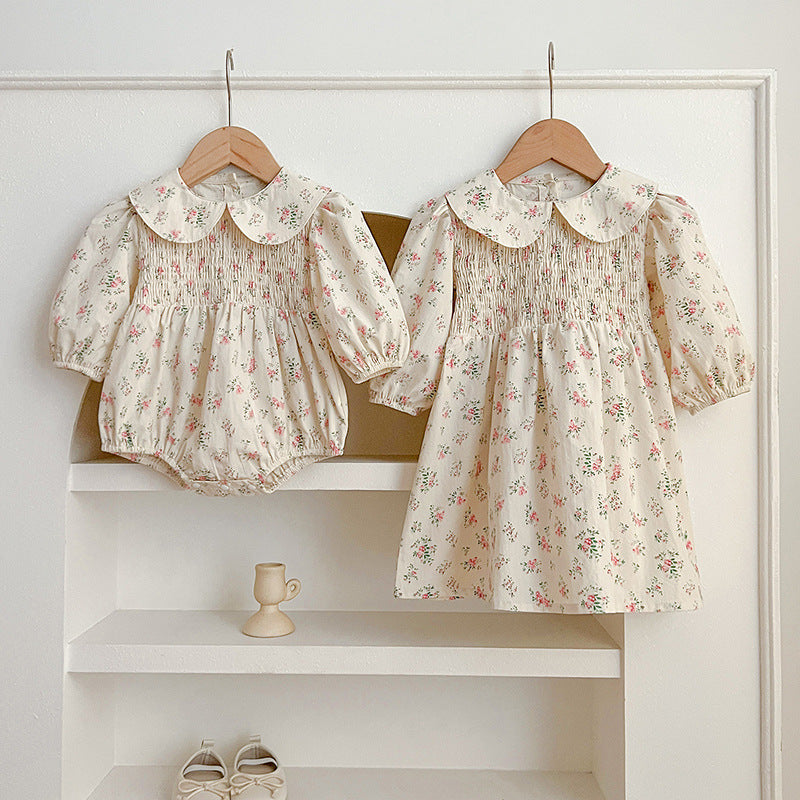 A pink floral print baby onesie with a Peter Pan collar, perfect for autumn wear, showcasing its soft fabric and charming design.