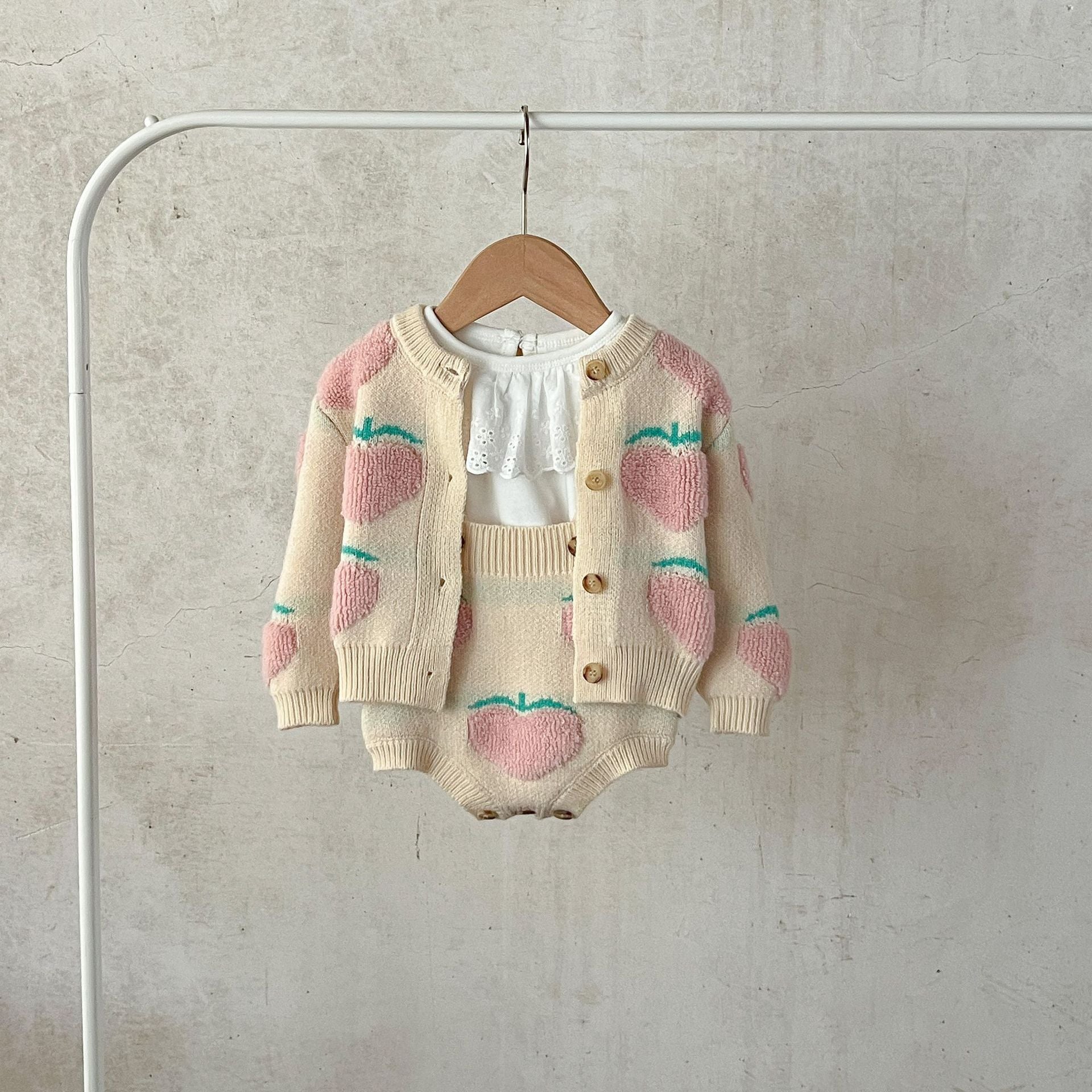 Baby girl wearing a beige cardigan combo with peach embroidery, showcasing a stylish and comfortable outfit for infants.