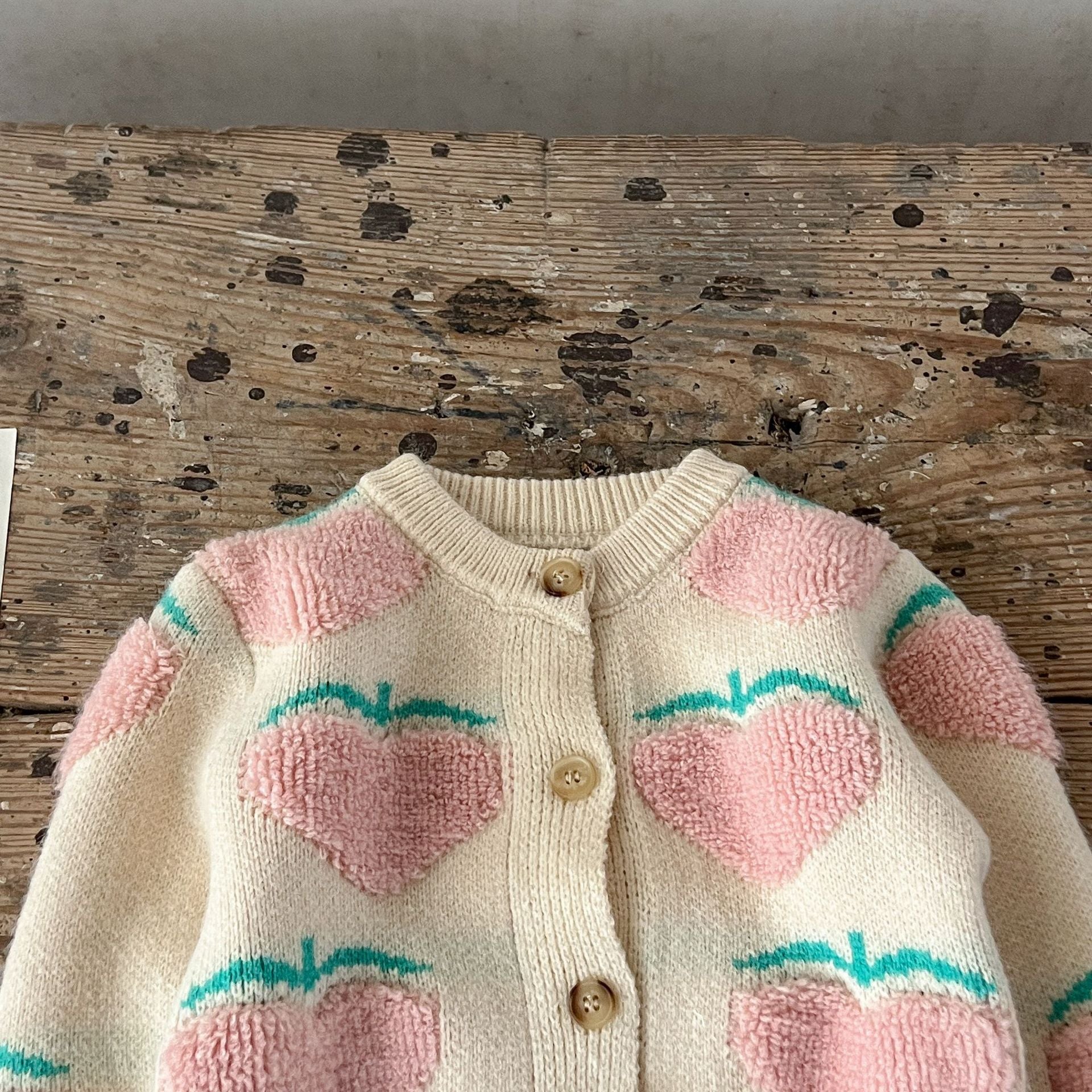 Baby girl wearing a beige cardigan combo with peach embroidery, showcasing a stylish and comfortable outfit for infants.