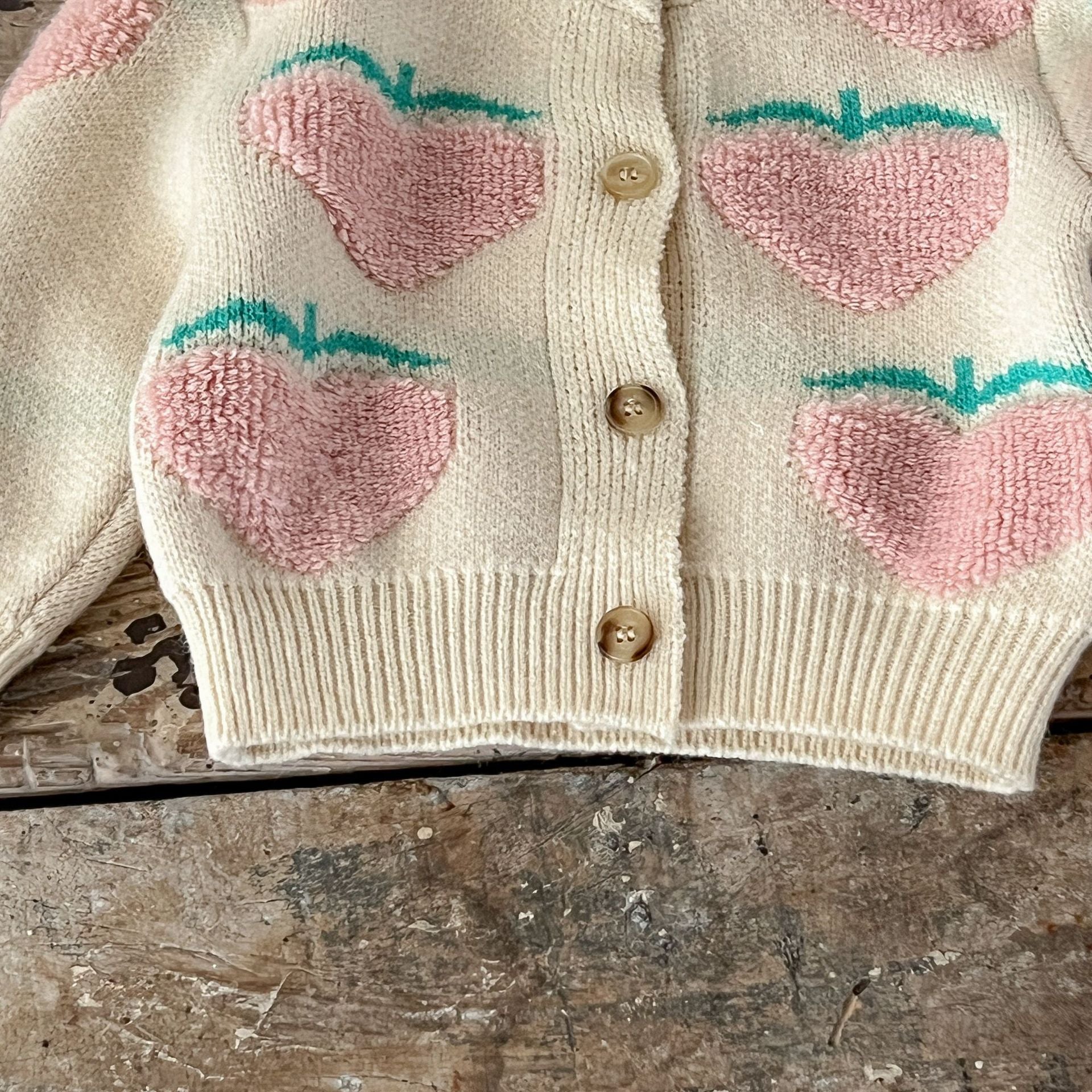 Baby girl wearing a beige cardigan combo with peach embroidery, showcasing a stylish and comfortable outfit for infants.