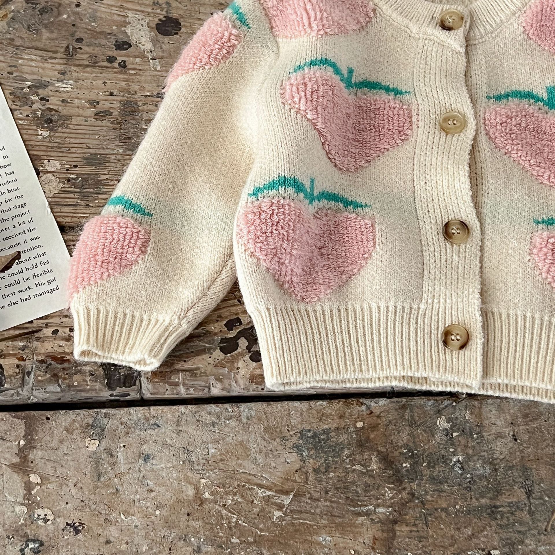 Baby girl wearing a beige cardigan combo with peach embroidery, showcasing a stylish and comfortable outfit for infants.