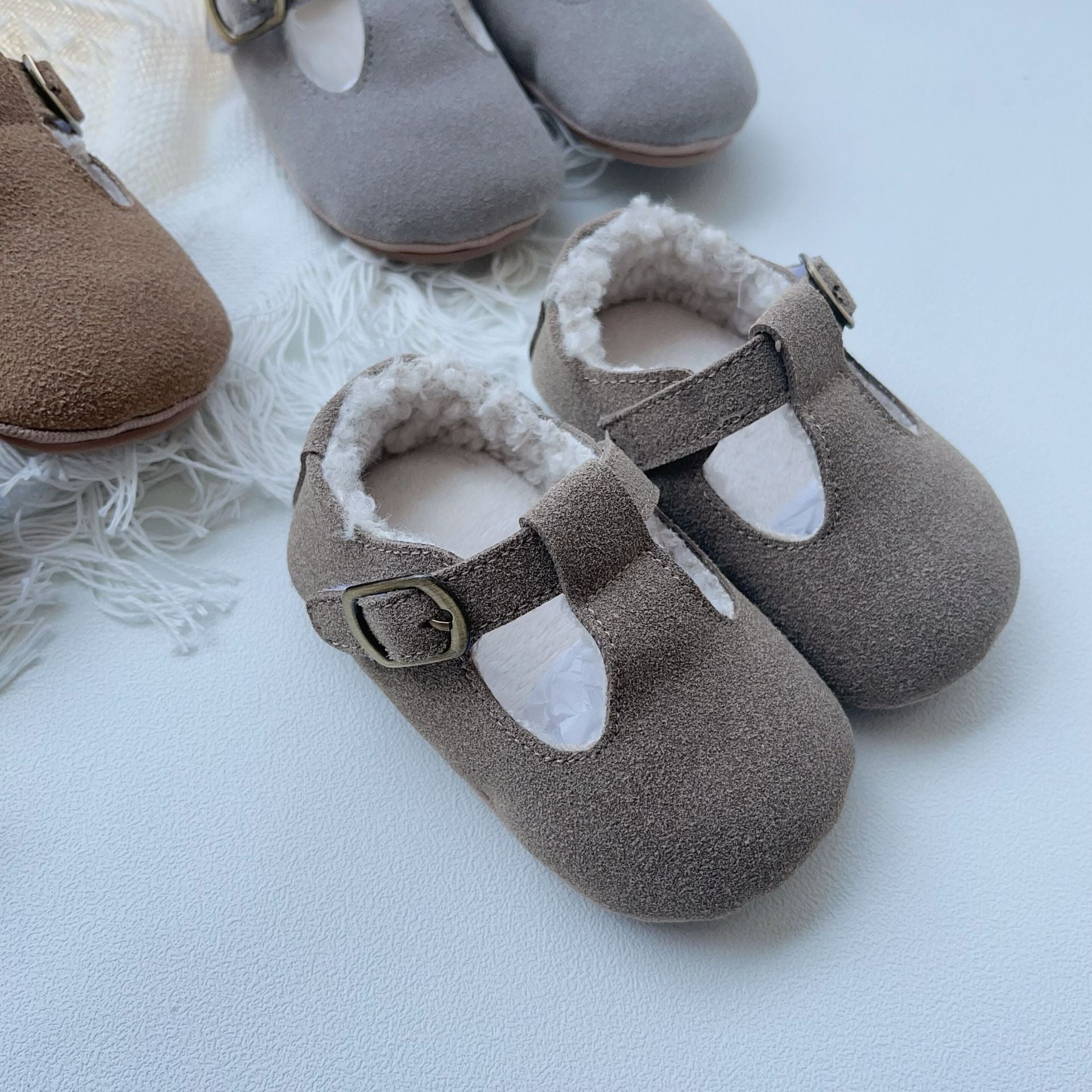 New Arrival Winter Baby Girl Solid Color Plush Warm Anti-Slip Shoes in green, grey, and brown, showcasing their soft material and anti-slip sole.