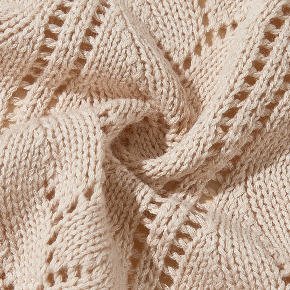 A cozy beige knitted baby blanket featuring a stylish hollow-out design, perfect for infants and toddlers.