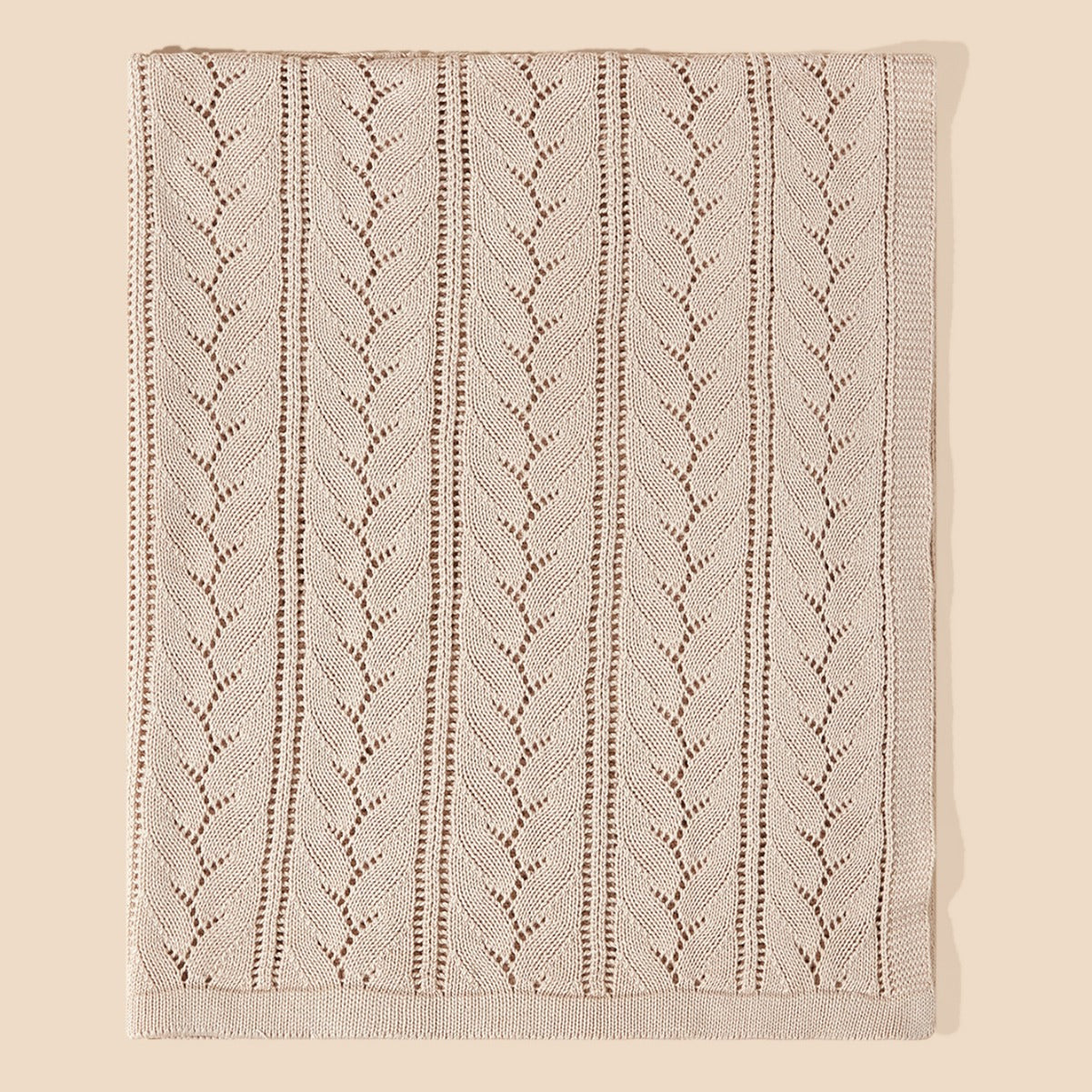 A cozy beige knitted baby blanket featuring a stylish hollow-out design, perfect for infants and toddlers.