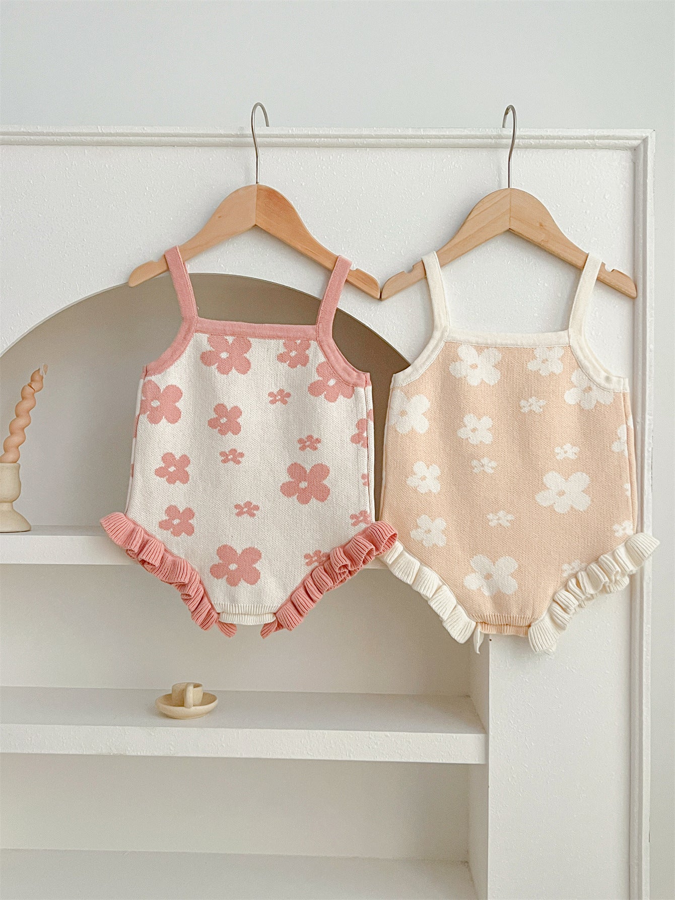 A cute summer dress for baby girls featuring a floral pattern, sleeveless design, available in pink and beige colors.