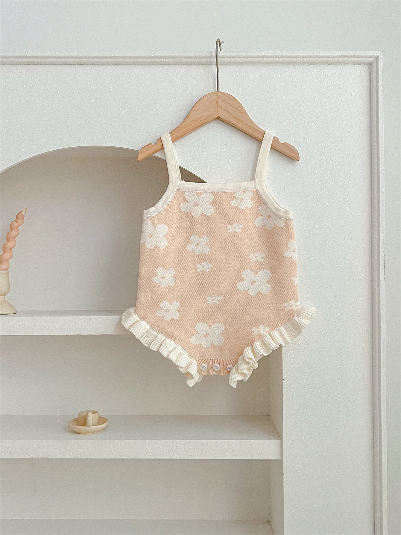 A cute summer dress for baby girls featuring a floral pattern, sleeveless design, available in pink and beige colors.