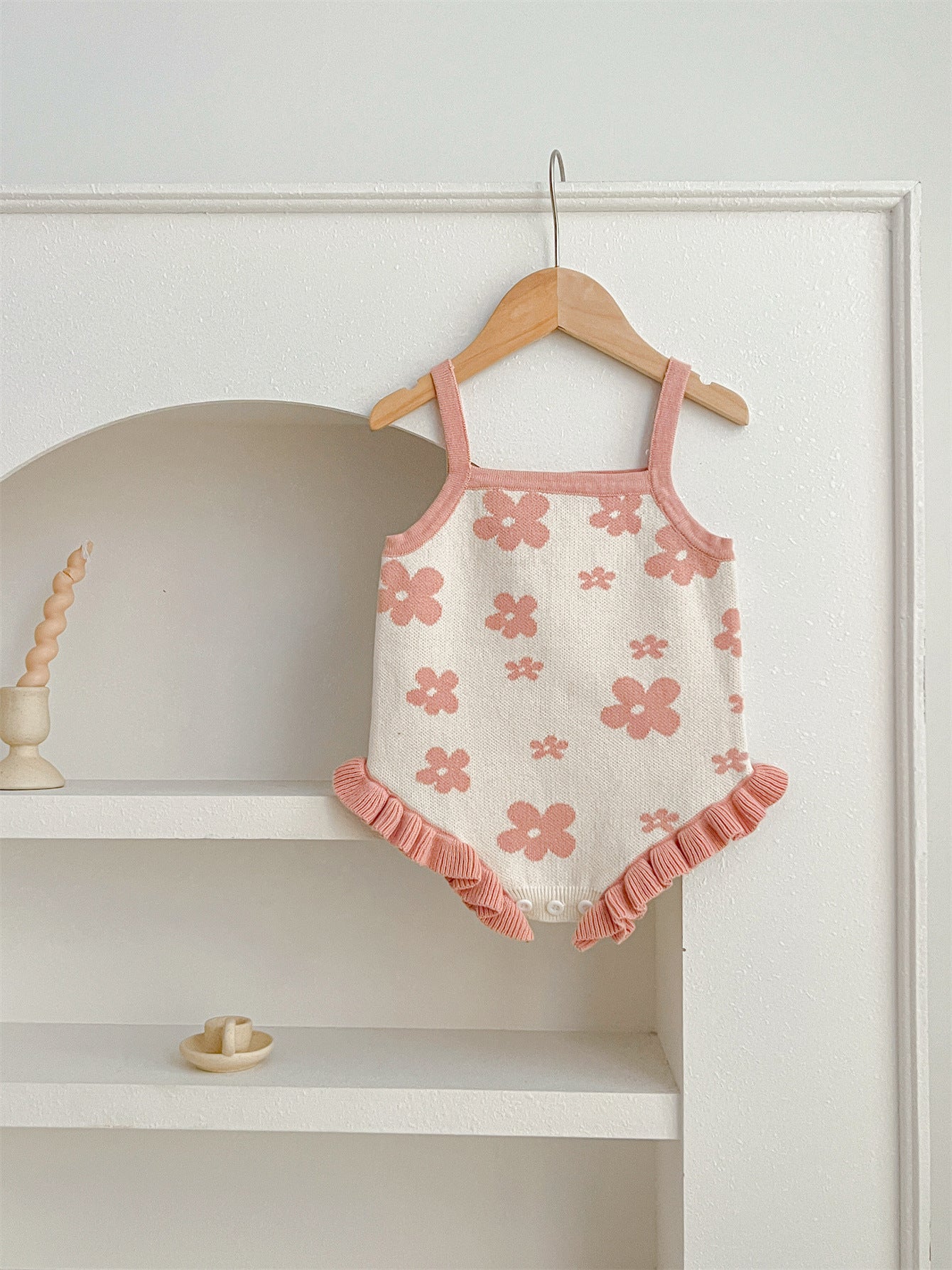 A cute summer dress for baby girls featuring a floral pattern, sleeveless design, available in pink and beige colors.