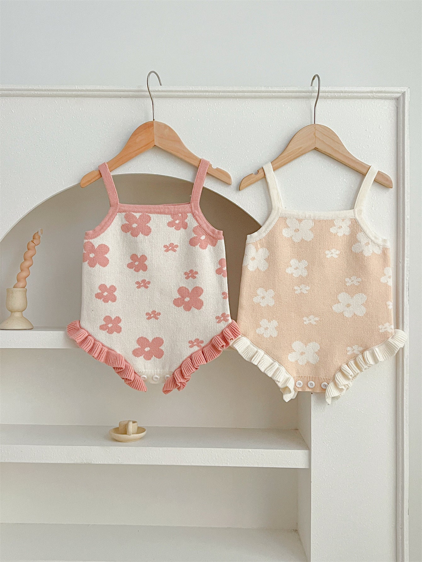 A cute summer dress for baby girls featuring a floral pattern, sleeveless design, available in pink and beige colors.