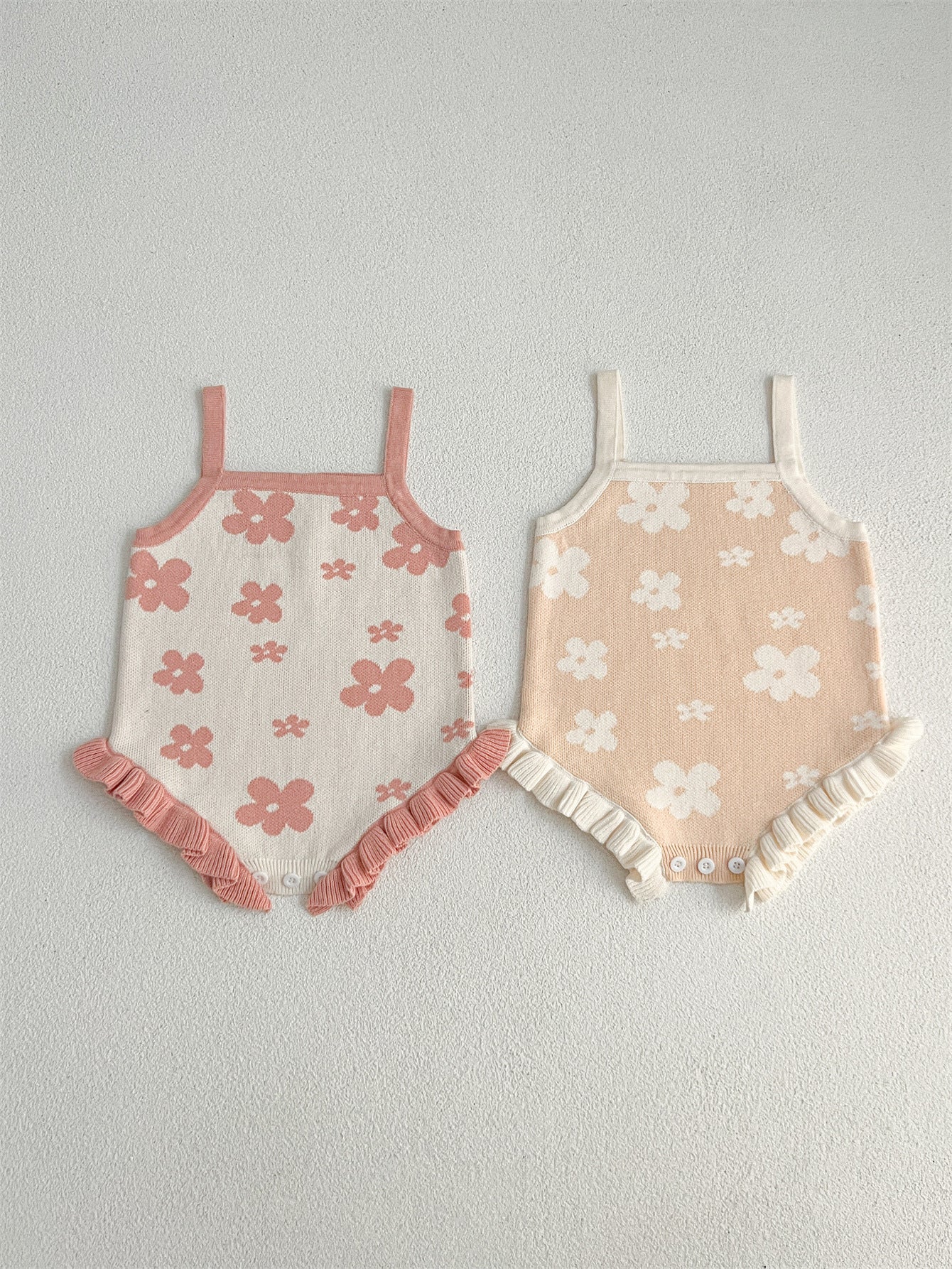 A cute summer dress for baby girls featuring a floral pattern, sleeveless design, available in pink and beige colors.