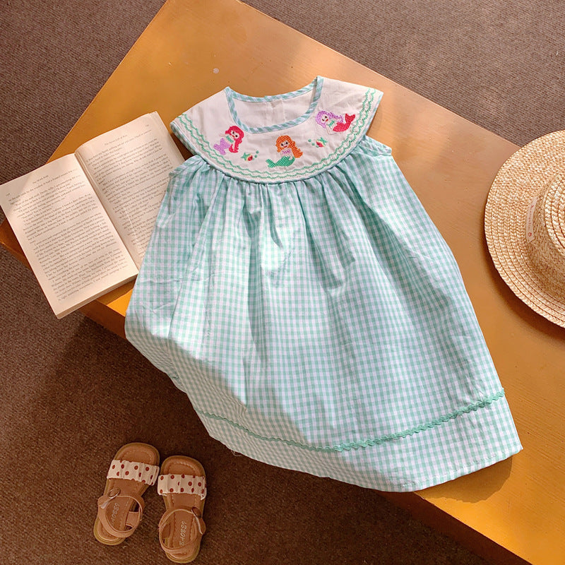 A cute summer dress for baby girls featuring a plaid pattern and mermaid embroidery in pink and blue colors.