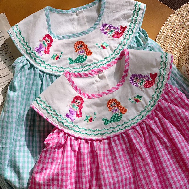 A cute summer dress for baby girls featuring a plaid pattern and mermaid embroidery in pink and blue colors.