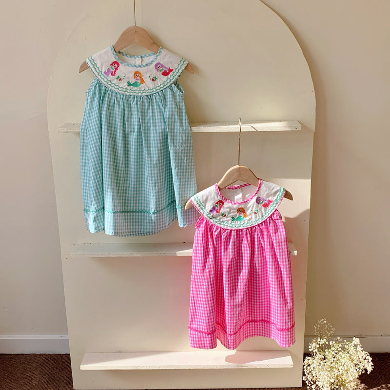 A cute summer dress for baby girls featuring a plaid pattern and mermaid embroidery in pink and blue colors.